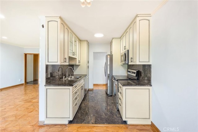 kitchen featuring cream cabinetry, decorative backsplash, sink, and stainless steel appliances