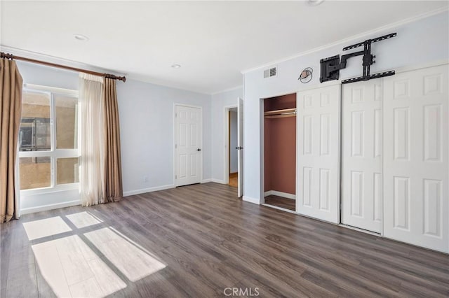 unfurnished bedroom featuring dark wood-type flooring and crown molding