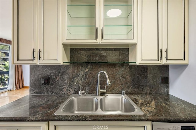 kitchen featuring sink, dark stone countertops, cream cabinetry, and tasteful backsplash