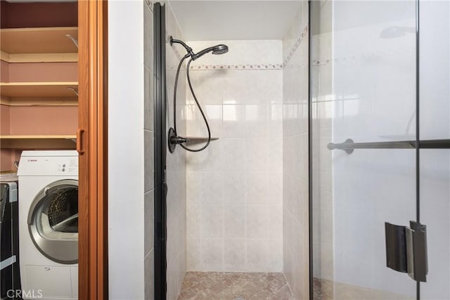 bathroom featuring washer / dryer and a shower with shower door