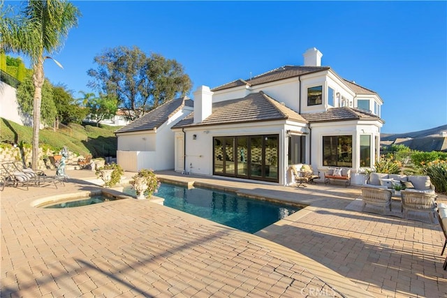 back of house with a patio area and an outdoor living space