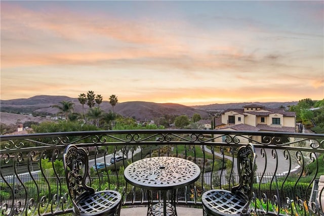 balcony at dusk featuring a mountain view