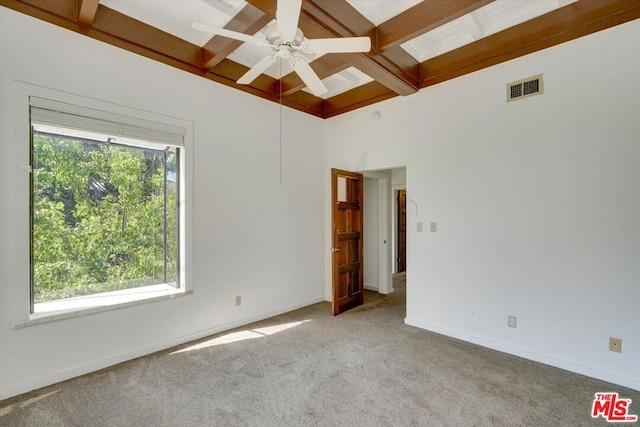 carpeted empty room featuring ceiling fan, beamed ceiling, and coffered ceiling