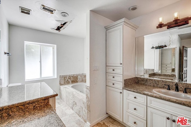 bathroom with tiled bath and vanity