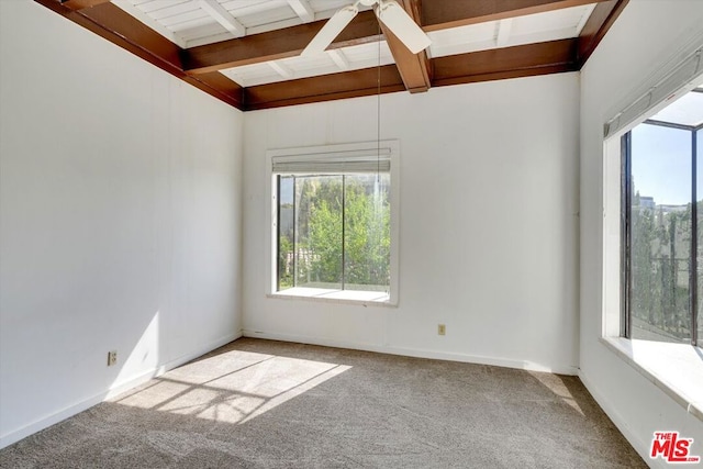 spare room with ceiling fan, carpet, and lofted ceiling with beams