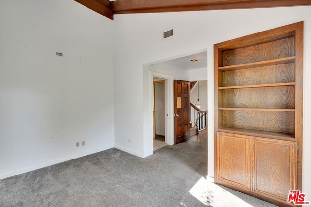 carpeted spare room with lofted ceiling