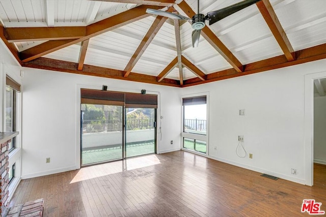 unfurnished living room with ceiling fan, lofted ceiling with beams, a fireplace, and hardwood / wood-style flooring