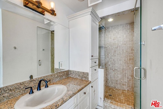 bathroom featuring walk in shower and vanity