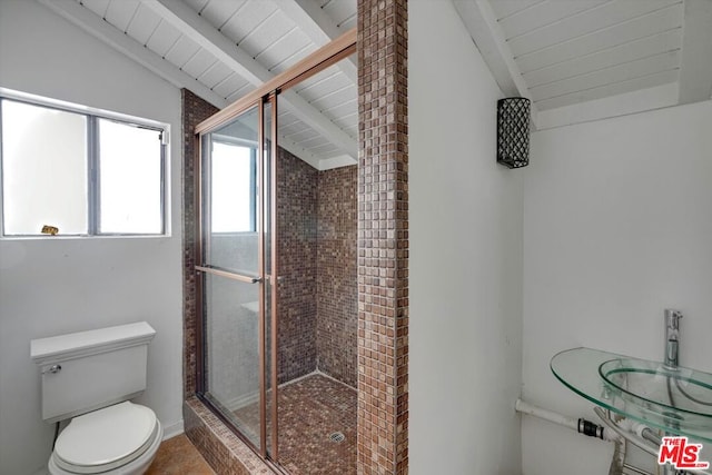 bathroom featuring toilet, walk in shower, and lofted ceiling with beams