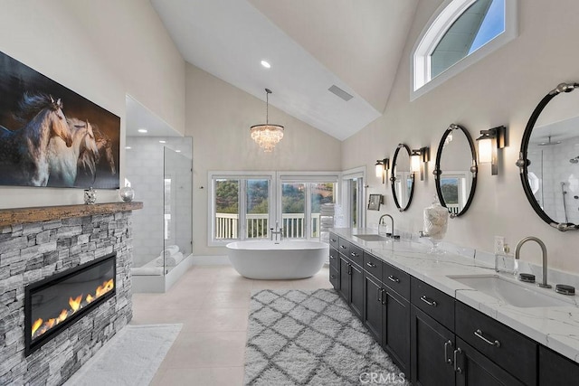 bathroom with separate shower and tub, vanity, tile patterned flooring, a fireplace, and a notable chandelier