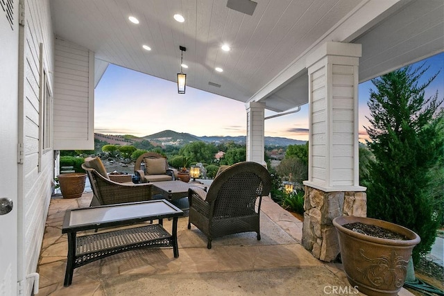 patio terrace at dusk with a mountain view and an outdoor hangout area