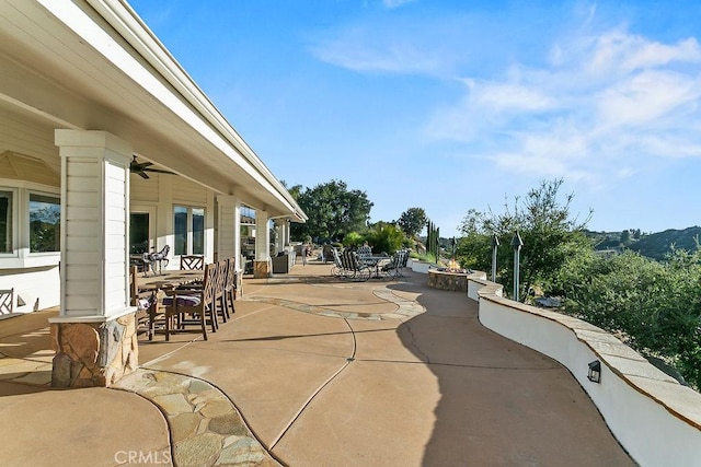 view of patio with ceiling fan and a fire pit