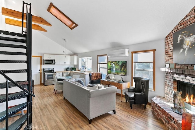 living room with light wood-type flooring, a fireplace, an AC wall unit, and beamed ceiling