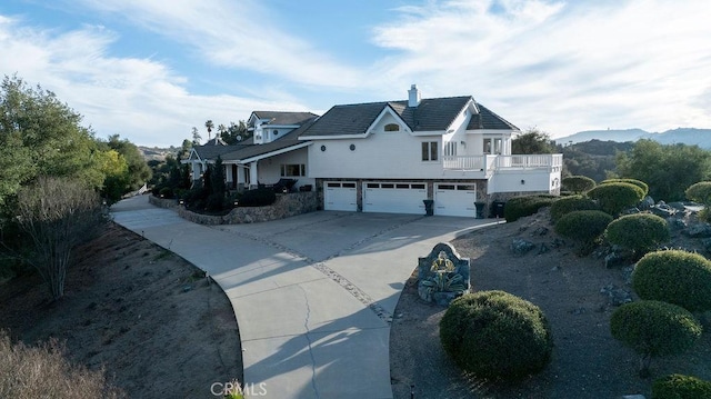 view of side of property with a garage, a balcony, and a mountain view