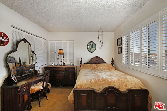 bedroom featuring a textured ceiling and carpet