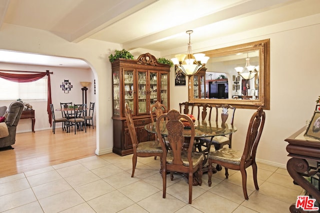 tiled dining room with beamed ceiling and an inviting chandelier