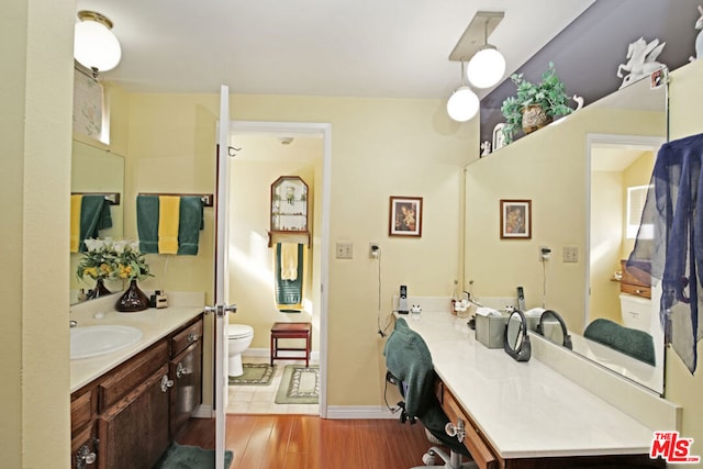 bathroom with toilet, hardwood / wood-style flooring, and vanity