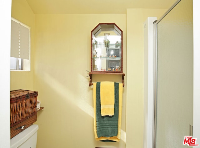 bathroom with an enclosed shower and toilet