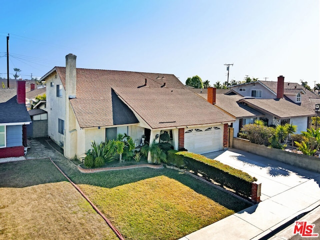 view of front of property with a garage and a front lawn