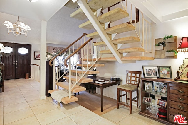 stairs featuring tile patterned flooring and a notable chandelier