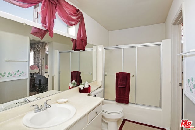 full bathroom with toilet, vanity, and shower / bath combination with glass door