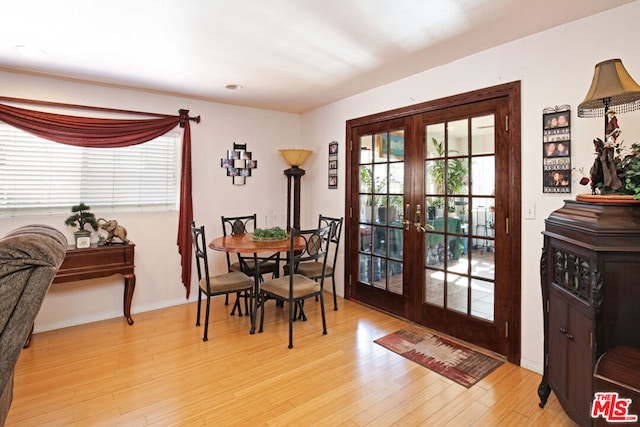 dining space with french doors and light wood-type flooring