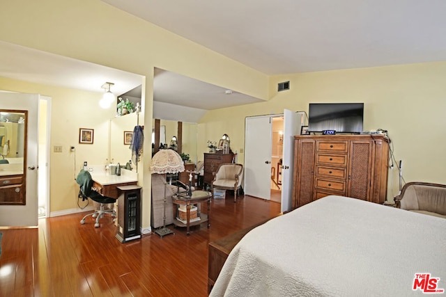 bedroom with dark hardwood / wood-style floors and lofted ceiling