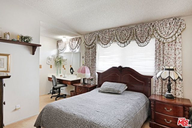 carpeted bedroom with a textured ceiling and vaulted ceiling