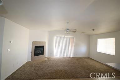 unfurnished living room with ceiling fan and carpet floors