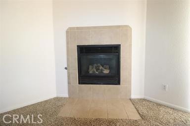 interior details featuring a tiled fireplace