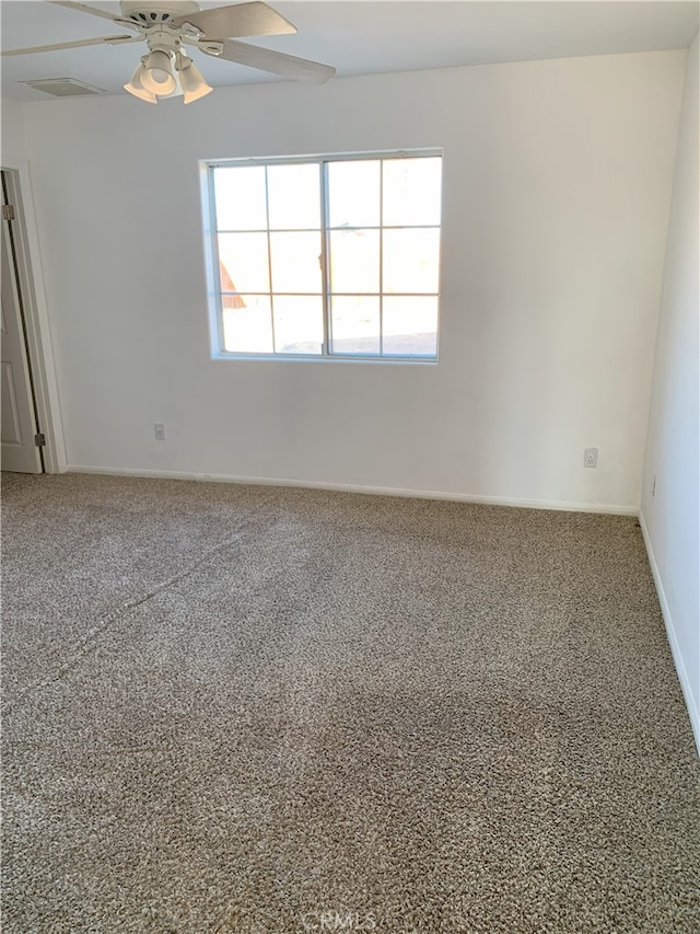 carpeted spare room with ceiling fan