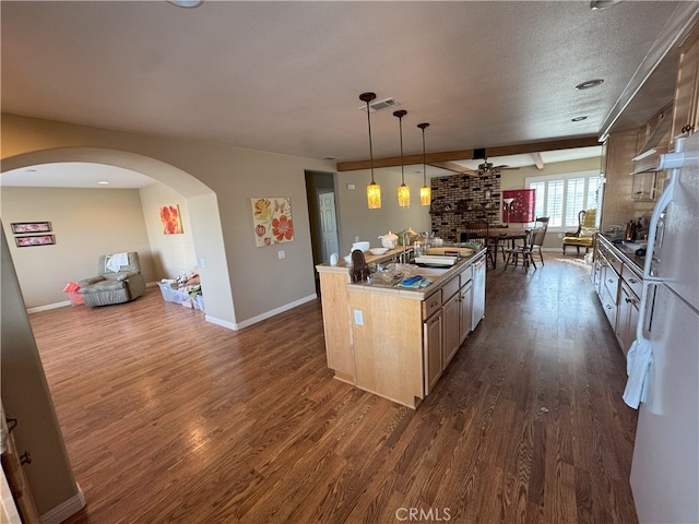 kitchen with light brown cabinets, dark wood-type flooring, pendant lighting, and a center island