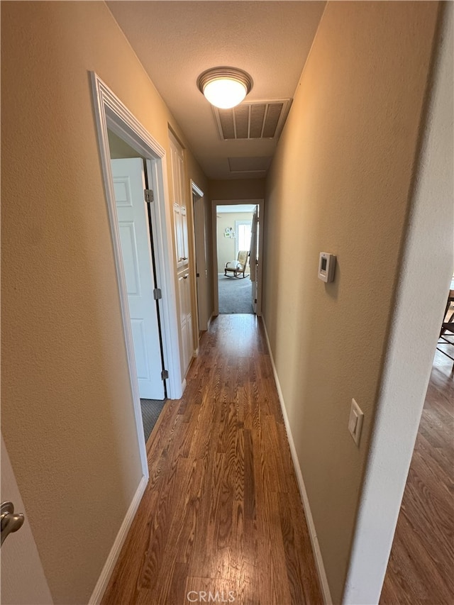 hallway with hardwood / wood-style flooring