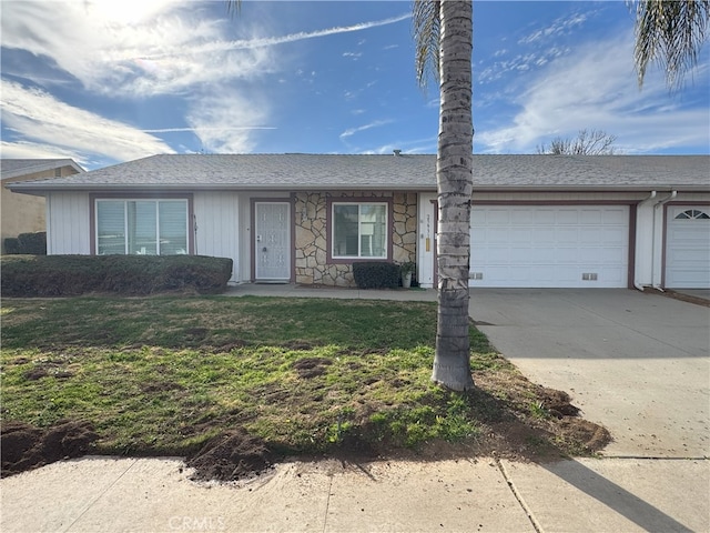 ranch-style home with a garage and a front lawn