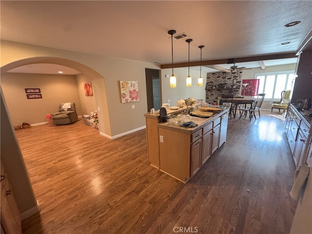 kitchen featuring decorative light fixtures, wood-type flooring, a textured ceiling, and a center island