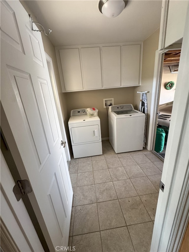 clothes washing area with cabinets, light tile patterned floors, and separate washer and dryer