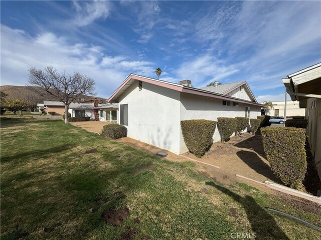 view of side of home with a yard