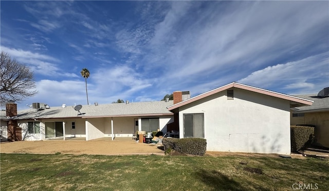 rear view of property with a lawn and a patio area