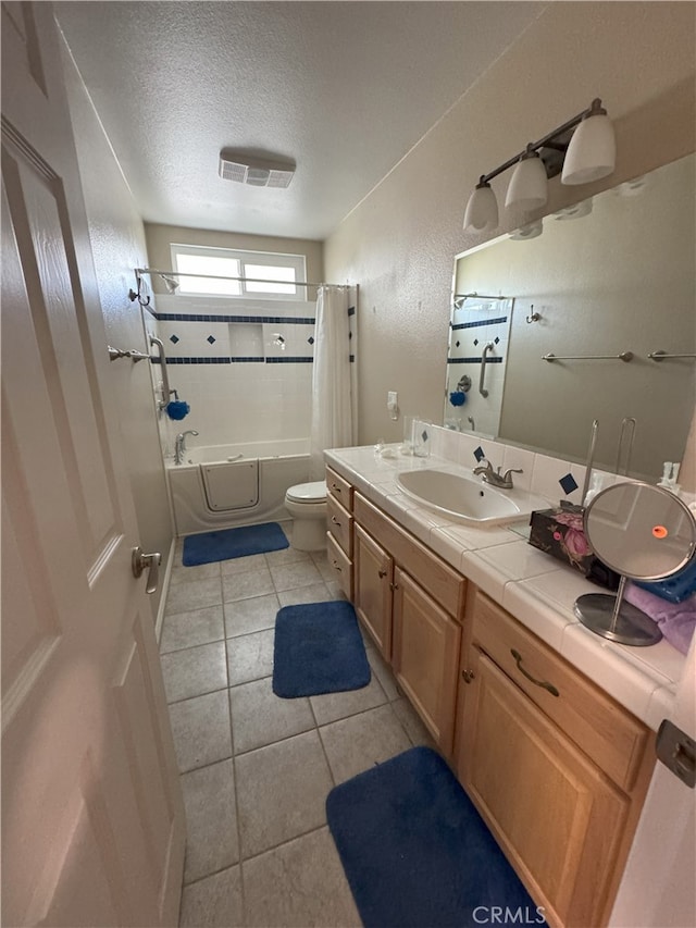 full bathroom featuring a textured ceiling, tile patterned floors, vanity, toilet, and shower / bath combo with shower curtain