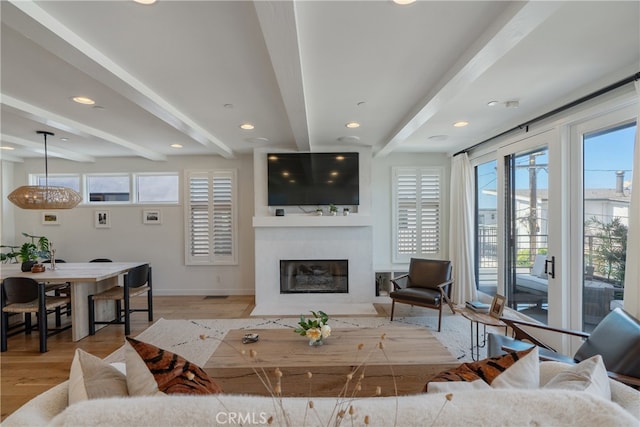 living room featuring beam ceiling and light hardwood / wood-style flooring