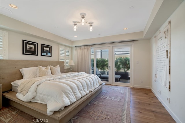 bedroom with access to exterior and wood-type flooring