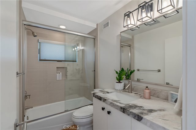 full bathroom with toilet, vanity, and shower / bath combination with glass door