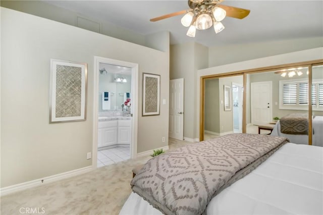 bedroom featuring lofted ceiling, connected bathroom, a closet, ceiling fan, and light colored carpet