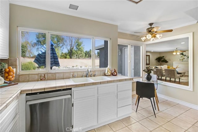 kitchen featuring stainless steel dishwasher, sink, tile counters, and white cabinetry