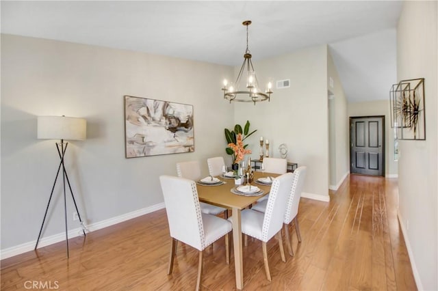 dining space with a notable chandelier and hardwood / wood-style floors