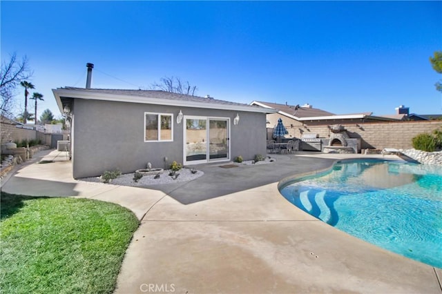 view of swimming pool featuring a fireplace and a patio