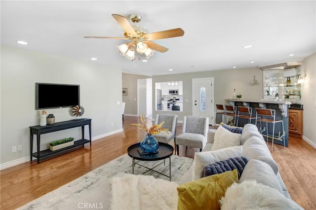 living room with ceiling fan and light hardwood / wood-style floors