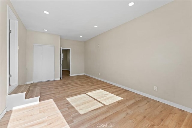 unfurnished bedroom with light hardwood / wood-style floors and a closet