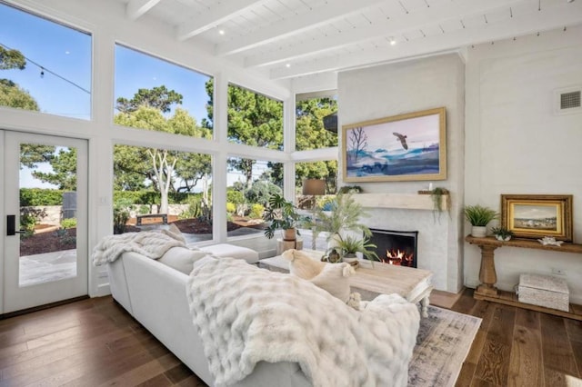 sunroom / solarium with a high end fireplace, beam ceiling, and wood ceiling