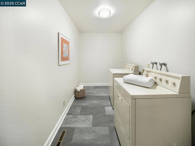 clothes washing area with washing machine and dryer